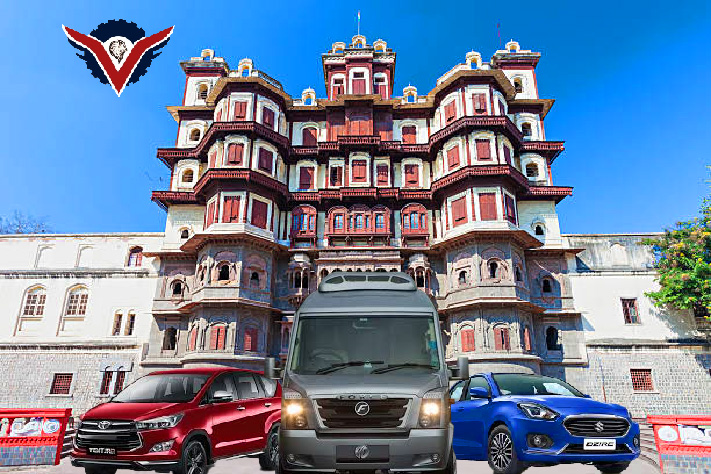 "Vishal Tour and Travels rental vehicles, including a Force Traveller, Toyota Innova, and Maruti Dzire, in front of Rajwada Palace, Indore."